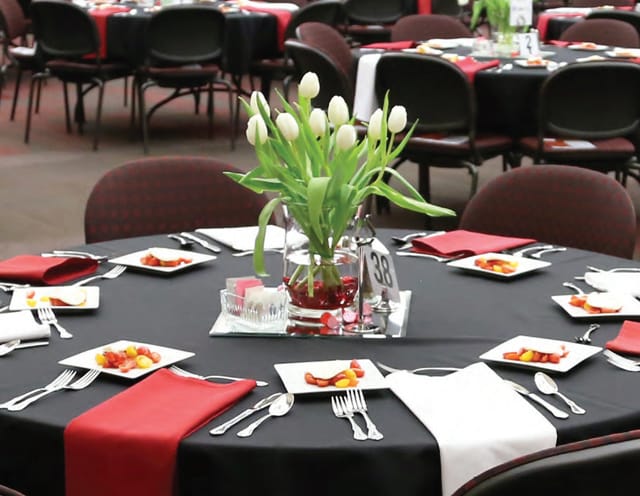 A banquet table set with flowers and place-settings.