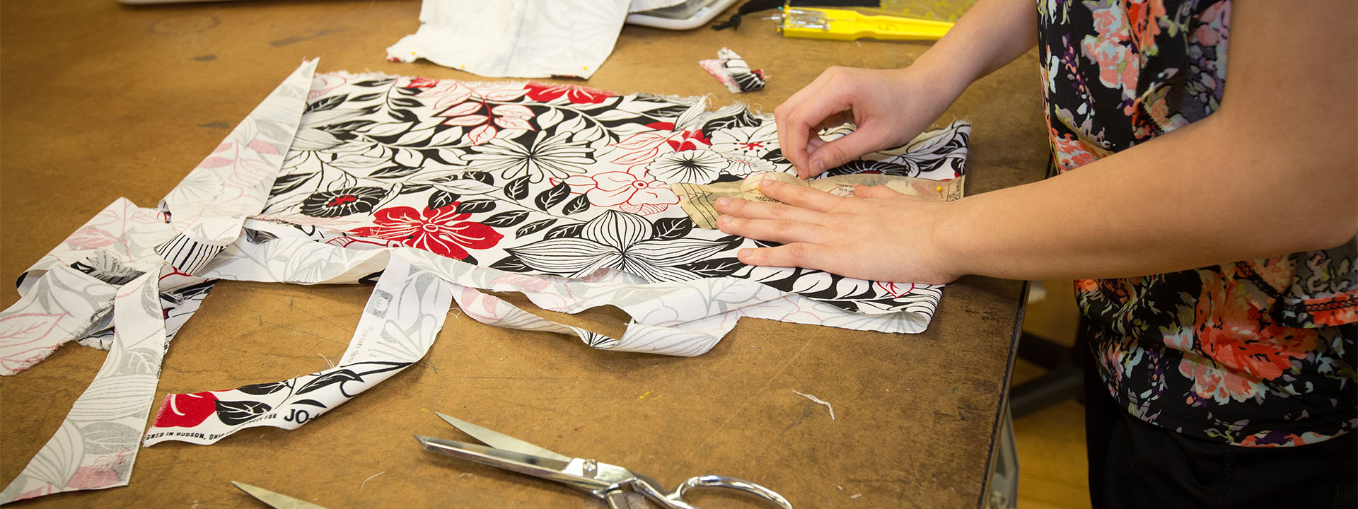 A woman pinning a pattern to fabric