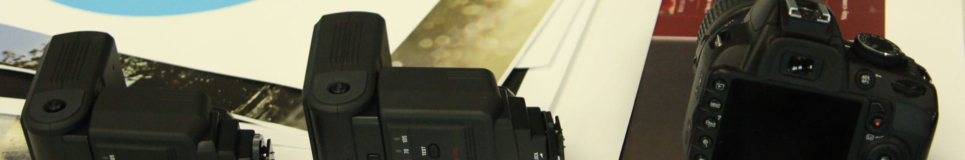 Digital camera and other equipment lay on a work table.