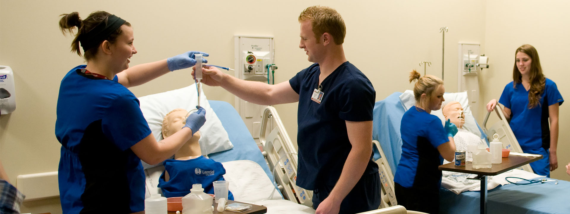 Students practicing fluid delivery to a mannequin