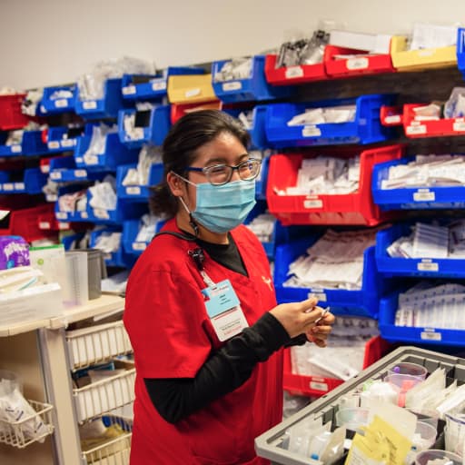 A Project SEARCH student smiling as she's organizing medical supplies.