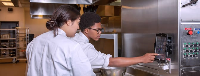 Two Culinary Arts students at work in the kitchen.