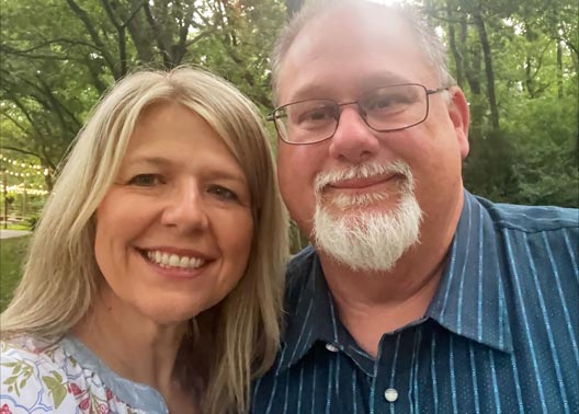 Leslie and Steve Cummings standing under a tree
